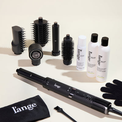 The Frizz-Free Routine Value Set, featuring the black TurboStyle Styling & Drying System, Top Coat, Frizz Care Shampoo, and Frizz Care Conditioner on a beige background